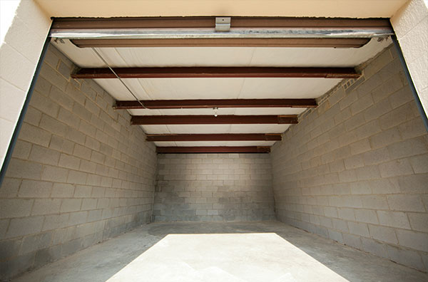 A large empty room with beams and concrete walls.